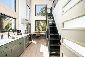 The kitchen/dining area has a stairway leading up to the loft