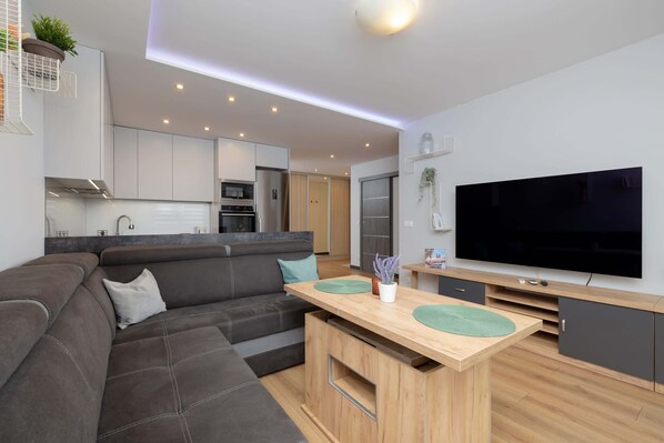A living room with a large corner sofa in grey tones inviting you to relax.