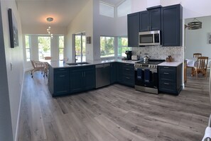 Large Kitchen with blue cabinets and marble backsplash. 