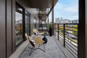 Balcony / Patio accessible through the living room and 2nd bedroom featuring outdoor furnishings for dining and lounging accompanied with city views.