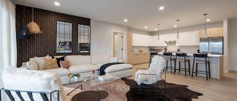 Cozy modern living room featuring a Smart TV, Patio access with city views and designer decor with plush furnishings.