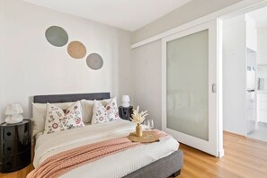 A second bedroom with a queen sized bed & plush pillows.