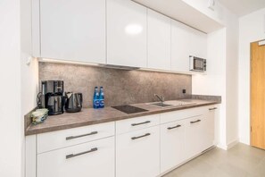 Kitchenette with plenty of kitchen utensils and dishes. 
