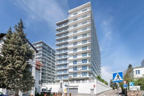 The modern exterior of the residential building, featuring glass balconies and a sleek design.
