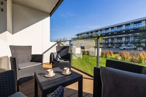 A balcony with outdoor seating and a view of the surrounding residential complex.

