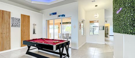 Modern Boho vibes transform this spacious area—complete with a pool table and unique lighting