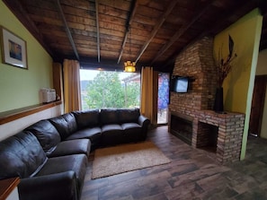 living room with cable tv and wood chimney