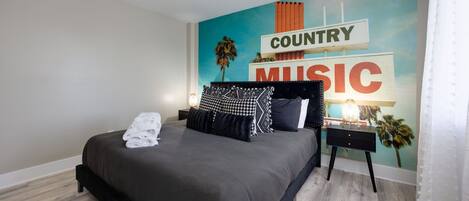 Immerse yourself in the world of country music with this mesmerizing mural adorning the walls of this cozy bedroom, creating a harmonious retreat for relaxation and inspiration