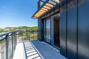 A modern balcony with sleek railings, offering a scenic view of the surrounding area and plenty of natural light.
