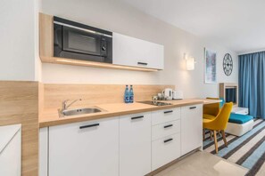 Kitchenette with plenty of kitchen utensils and dishes. 