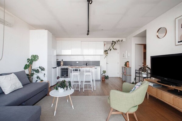 The living area evokes a calming vibe, brimming with greenery and natural light.  