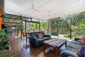 Take a moment to unwind on the deck's outdoor sofa, book in hand, and soak in the peaceful ambiance, all while under the gentle breeze of the ceiling fan. 