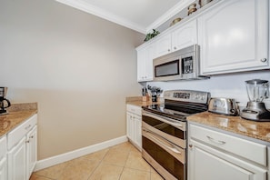 The fully equipped kitchen features granite countertops and stainless-steel appliances.