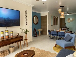 Enter our inviting living room featuring a 65-inch TV, a luxurious sofa bed.