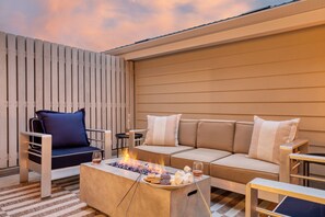 Outdoor lounge at Pacific Villa offers comfortable seating and an electric firepit.