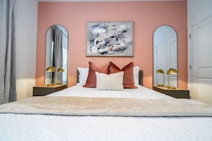 This beautiful, cozy bedroom that exudes modern elegance and comfort. The room is adorned with a plush, inviting bed that promises restful nights. The soft, warm hues of the walls create a serene atmosphere, perfect for relaxation after a day of exploration. Every detail, from the chic artwork to the sleek furnishings, is carefully selected to ensure your utmost comfort and satisfaction.