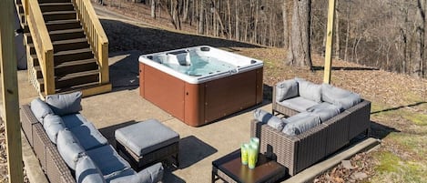 Backyard featuring a hot tub, swinging benches, and outdoor gathering