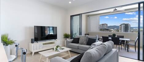 The light-filled living area offers two cosy sofas to settle in with a movie, while glass doors create a seamless flow out to the balcony. 
