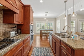 Step into a kitchen that beautifully combines mid-century aesthetics with modern luxury, showcasing sleek marble countertops that elevate both style and functionality.