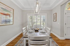 Gather around in style with this elegant 6-seater dining area, set against a backdrop of pristine white interiors.