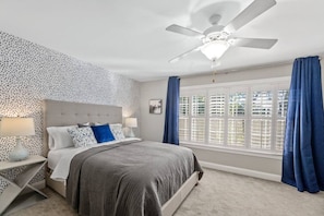 Indulge in serenity within this stunning bedroom, featuring a luxurious queen bed and expansive windows adorned with both curtains and blinds, offering the perfect blend of comfort and privacy. Located on the ground floor.