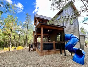 Slide, hot tub, outdoor dinning area with gas fireplace, fire pit with seating