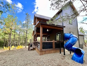 Slide, hot tub, outdoor dinning area with gas fireplace, fire pit with seating