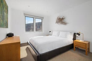 Bedroom 1 - Queen bed furnished with dresser, wardrobe, and black out blinds