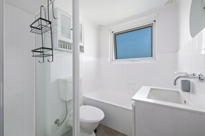 Modern and bright bathroom with shower and bath.