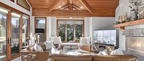 Cozy living room with vaulted ceilings and wood burning fireplace.