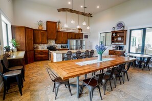 Fully equipped kitchen, two dining tables, breakfast bar, and coffee bar.