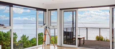 Wall-to-wall windows in the living area offer panoramic views across the bay. 
