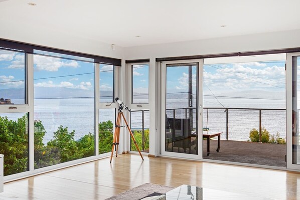 Wall-to-wall windows in the living area offer panoramic views across the bay. 
