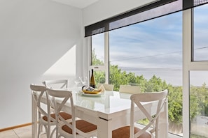 Share meals at the six-seater dining table, where views overlook Opossum Bay Beach. 

