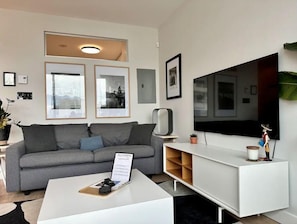 Sleek and modern living area, equipped with a large flat-screen TV.