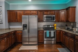 The stainless steel appliances glisten under the soft ambient light.