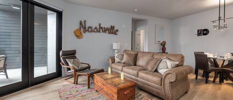 Bright open floor living space featuring SMART flat-screen TV, contemporary furnishings, and access to the outdoor corner patio.