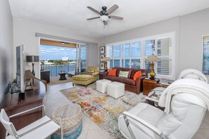 Living Room Features Custom Made Furniture, Smart TV, and Direct Access to the Private Waterfront Balcony