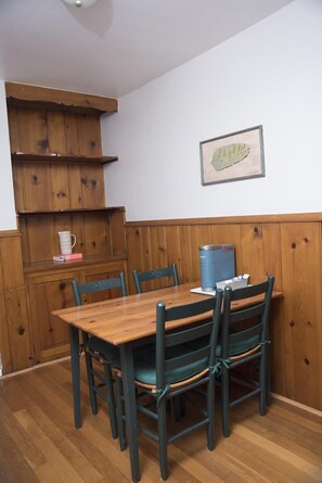 Kitchen table with 4 chairs and Keurig coffee maker.