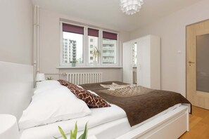 A cozy seating area with a brown throw and white cushions, complemented by bright decor.
