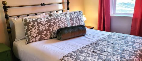 Queen bed, sitting area and large streaming TV in the main level master bedroom