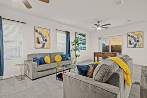 Bringing the fun indoors, this open concept living room features foosball, inviting you to gather with friends and family for friendly competition and endless entertainment.