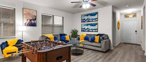 Bringing the fun indoors, this open concept living room features foosball, inviting you to gather with friends and family for friendly competition and endless entertainment.