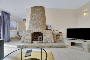 The living room/diner has a sofa, double sofa bed, coffee table, and smart TV.