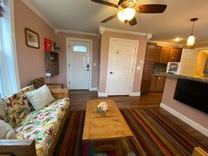 This is a view from the love seat by the back door.  You can see the front door, closet, desk, living room, part of the kitchen.