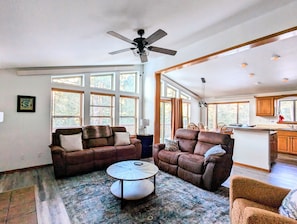 Bright & open living room surrounded by trees