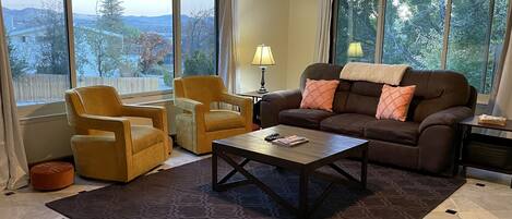 Huge living room with Views of mountains, downtown and tress.