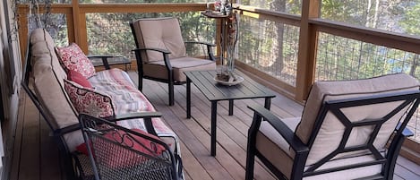 Screened in back porch for enjoying the peaceful backyard with view of the lake