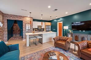 Speakeasy-inspired living space with open-floor concept. Featuring an entry hallway with bookshelf facade.