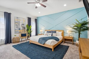 This inviting bedroom features a warm vibe, king bed, blue accent natural decor.
